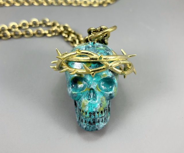 真鍮製のスカルネックレスに施された、金色の真鍮製のイバラの冠の緑青