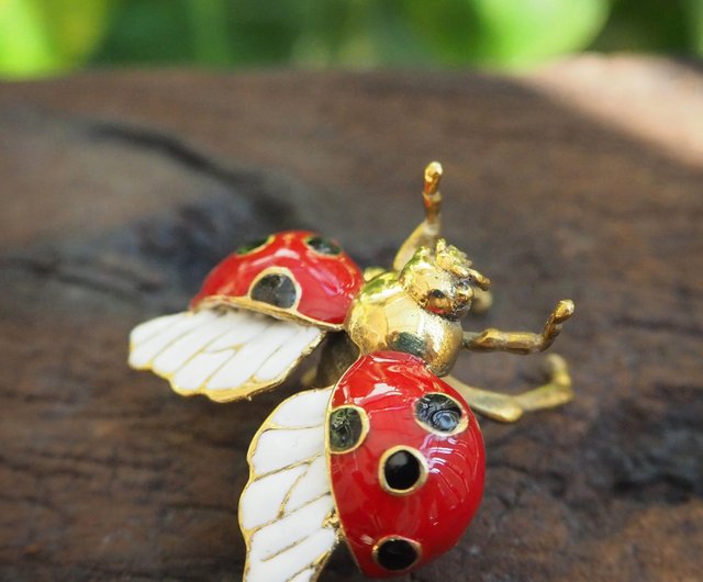 白いエナメルの羽が付いた真鍮製のフライングてんとう虫リング。サイズ