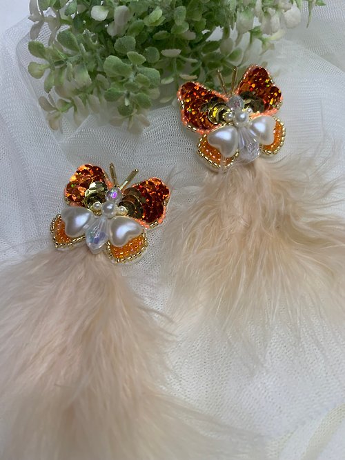 white-magic Piercing earrings, orange butterfly pattern Decorated with cream-colored feather