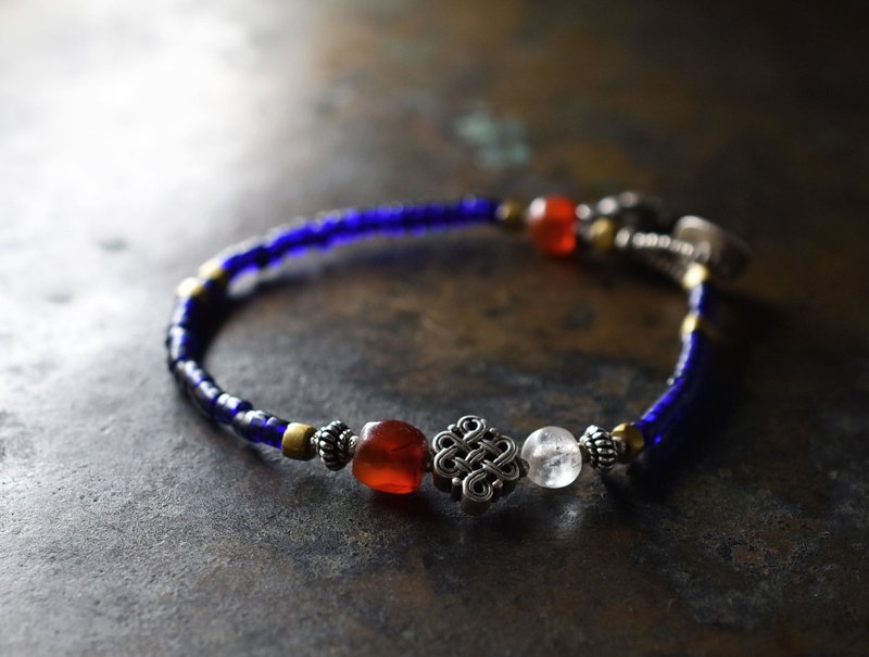 Bracelet of Mizoram carnelian and ancient crystal, endless knots, blue beads, old Orissa brass, and old Silver charms - สร้อยข้อมือ - แก้ว สีน้ำเงิน