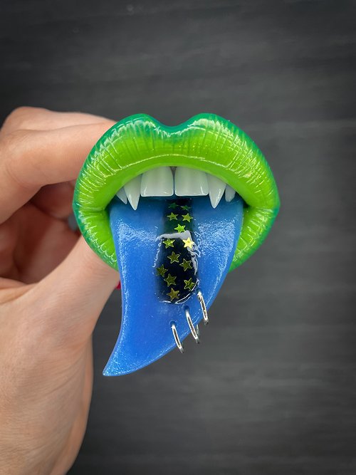 Polymer Diary Brooch. Green lips brooch with a blue tongue.