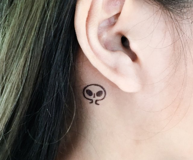 small sugar skull tattoo behind the ear