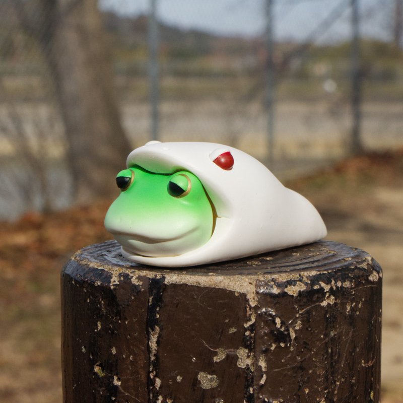 A frog seemingly hibernating in a sleeping bag that resembles a snake - Items for Display - Plastic Green