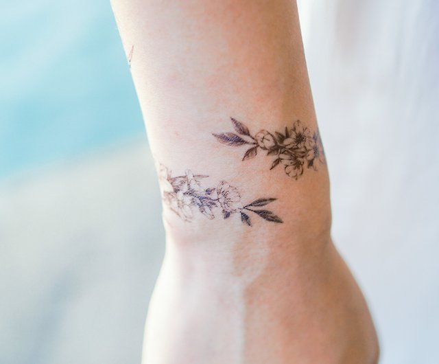 1. Delicate Flower Wrist Wrap Tattoo - wide 1