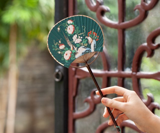 中国風に描かれた花と鳥がレトロな扇子に添えられており、古典的