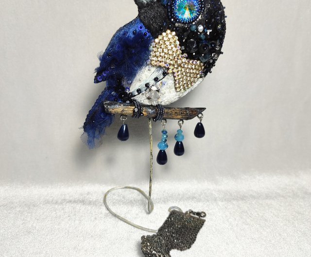 枝に青い鳥の刺繡が入ったブローチ。それは鳥の饗宴と呼ばれています