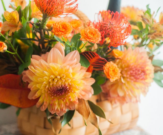 暖かいオレンジ色のギフトフラワーバスケット | フラワーテーブルの花 