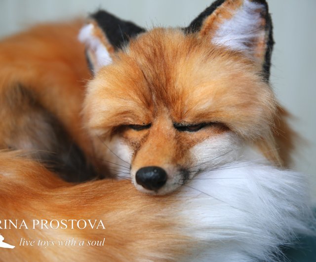 キツネのリアルなぬいぐるみ。眠っているキツネの子。写真で収集可能な