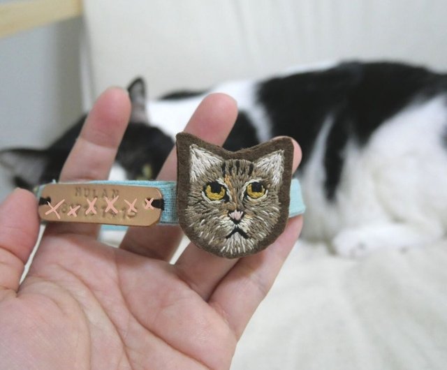 猫の顔のタグが刺繍された猫の首輪と電話番号を刻印する本革のラベル