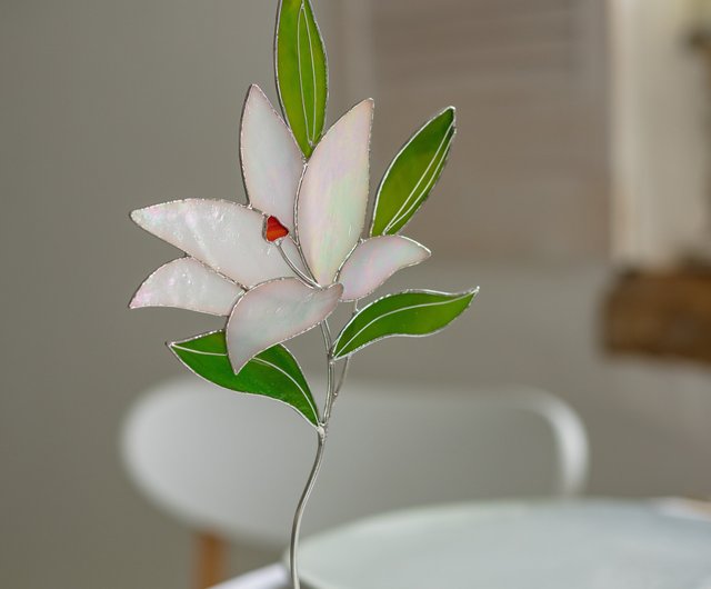 石のスタンドに置かれたステンド グラスのユリの花、テーブル装飾、花