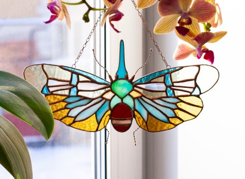 ステンドグラスの窓。 セミ、色付きの羽を持つ蝶。 ガラスサン