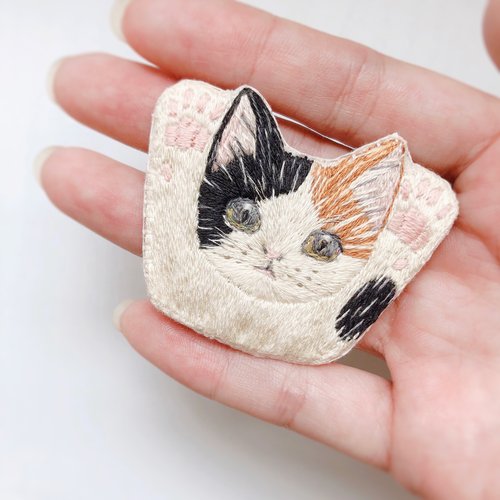 手を上げる猫の刺繍ブローチ